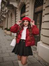A lady wears a down jacket and a denim skirt in winter.